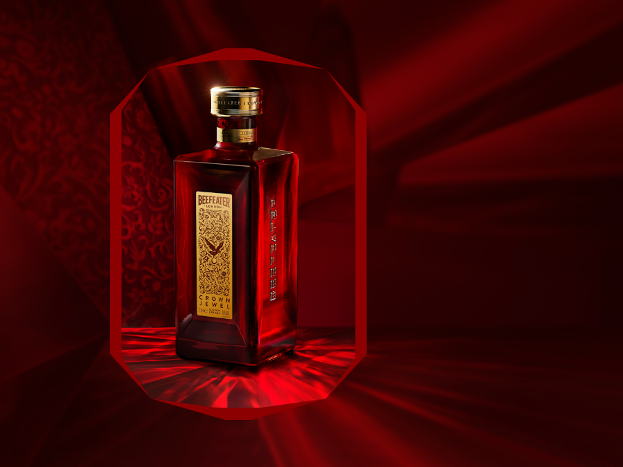A bottle of Beefeater Crown Jewel Gin, on a dark red background. The bottle appears as though inside a jewel. 