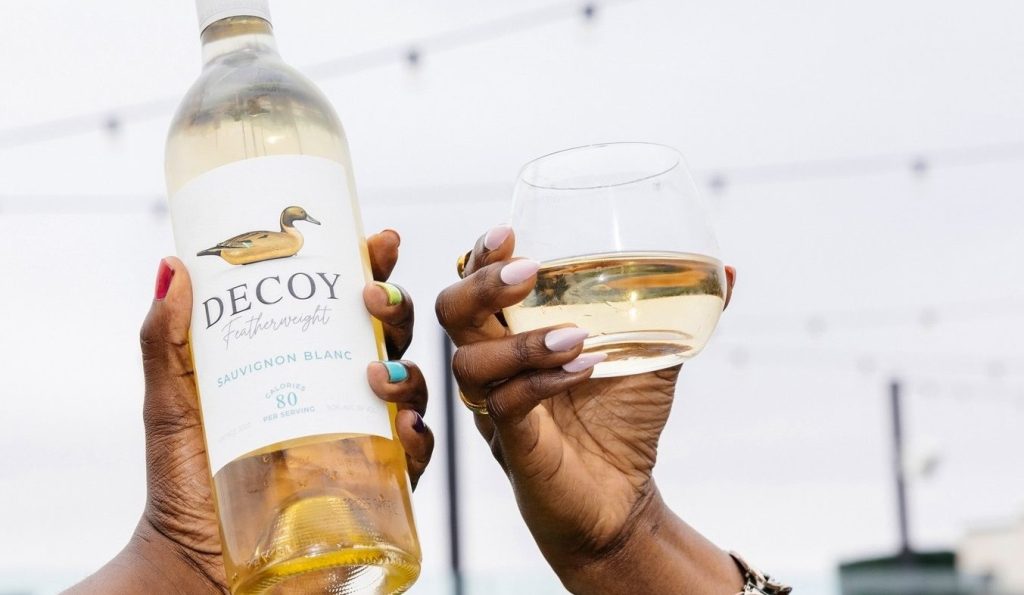 A bottle of Decoy Featherweight wine being held aloft