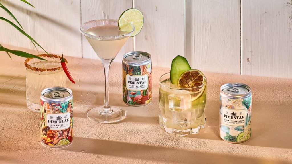 Tequila cocktails and cans on wooden table, white background